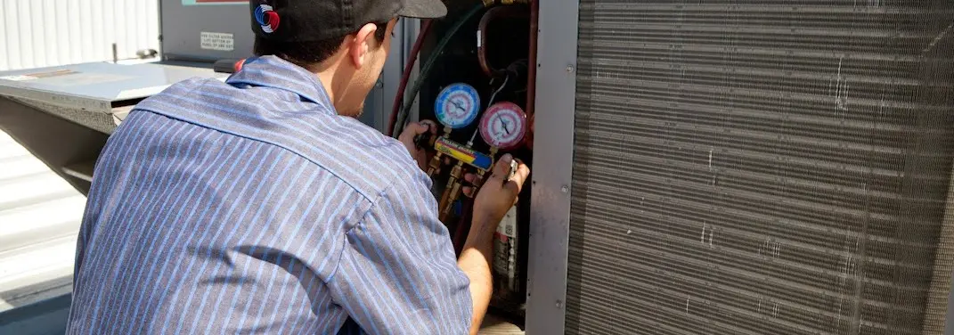 HVAC technician servicing a condenser unit in Granbury