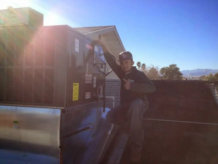 HVAC technician performing Heat Pump Repair on a rooftop unit in Granbury
